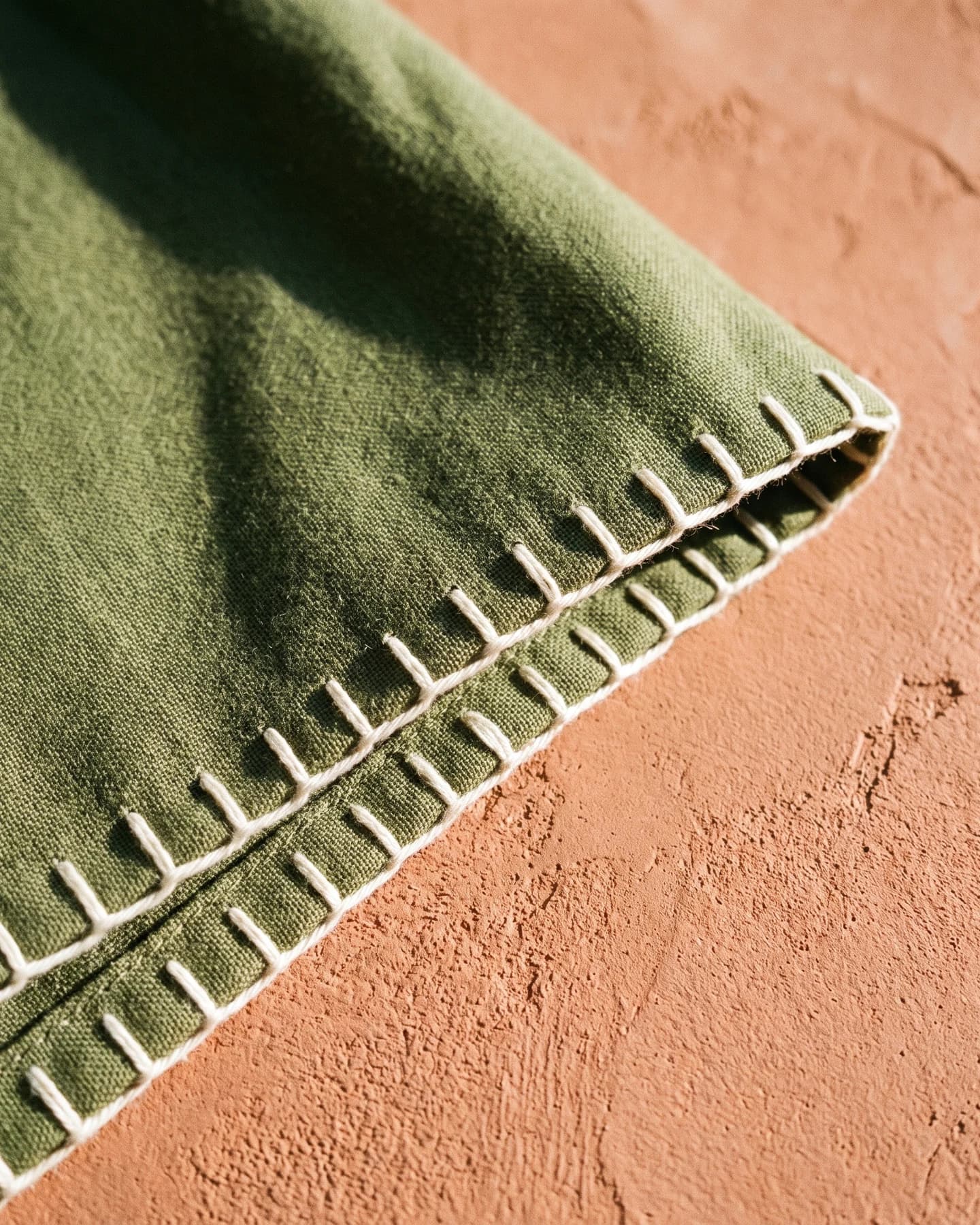 Pantalón Ibiza Largo en olivo con bordado crudo, en macro, la textura del material