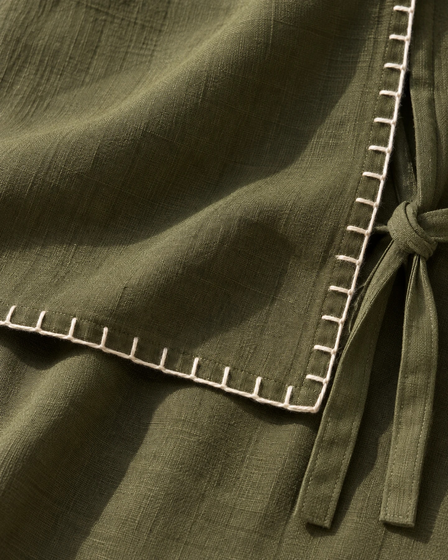Pantalón Ibiza Largo en olivo con bordado crudo, en macro, la textura del material