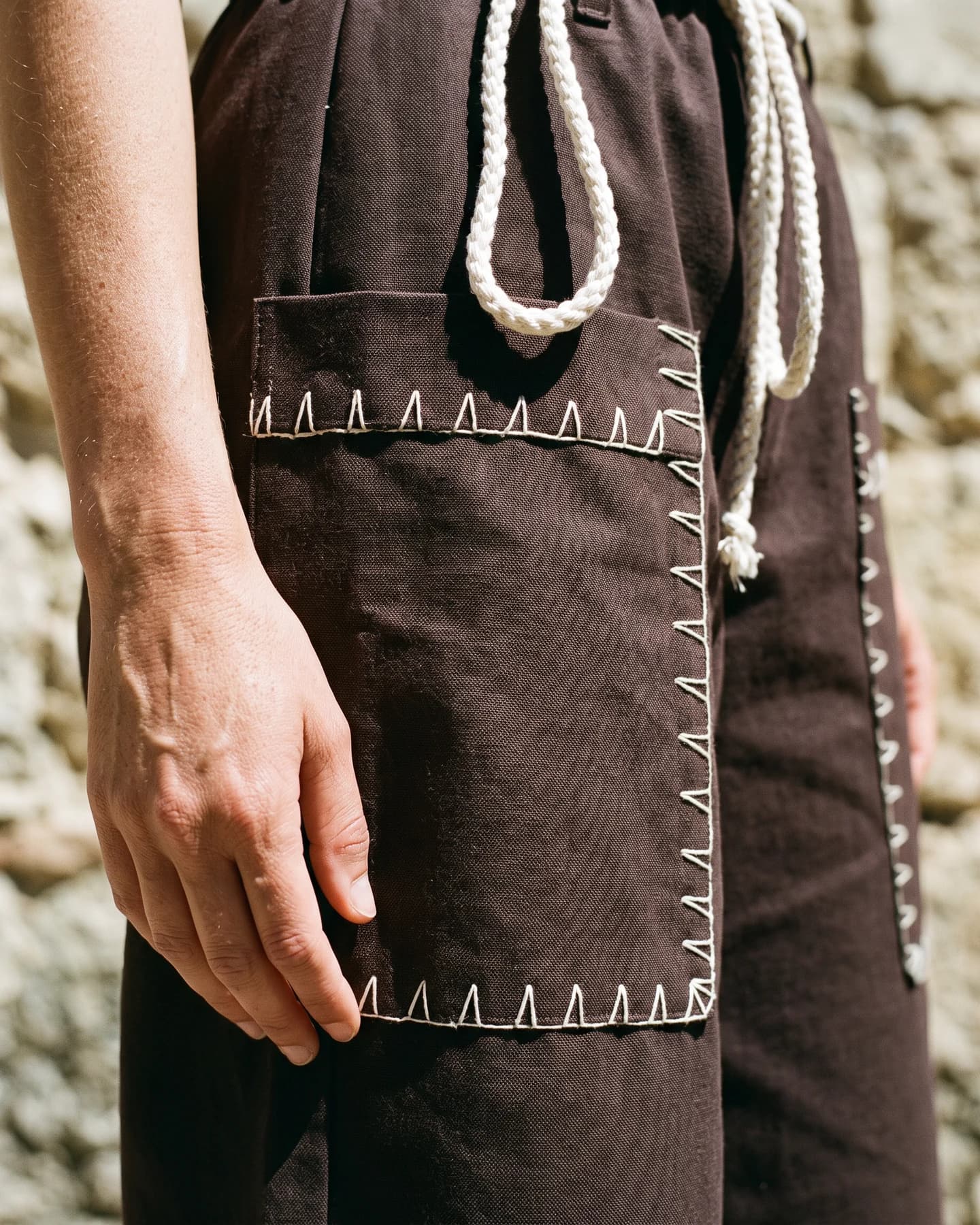 Pantalón York bordado a mano en café con bordado blanco, en detalle