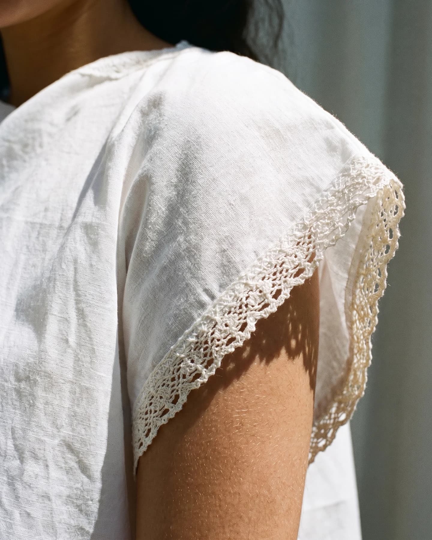 Poncho Cannes en blanco con bordado verde oliva, en detalle