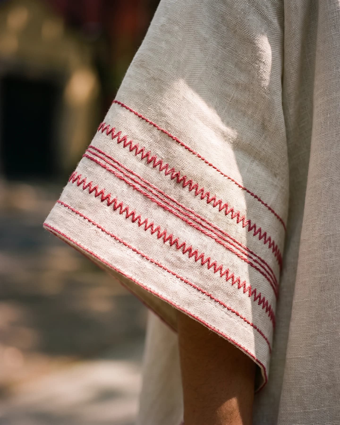 Poncho Marbella de lino en crudo con bordado rojo, en detalle